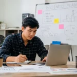Ilustrasi pengusaha muda sedang membangun bisnis dari nol dengan strategi dan perencanaan.
